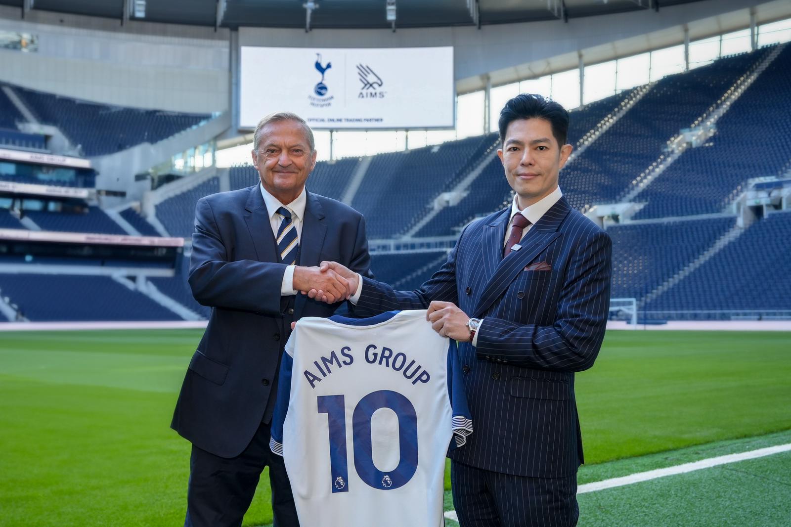 AIMS and Tottenham Hotspur executives shaking hands with an AIMS Group No. 10 shirt at the stadium